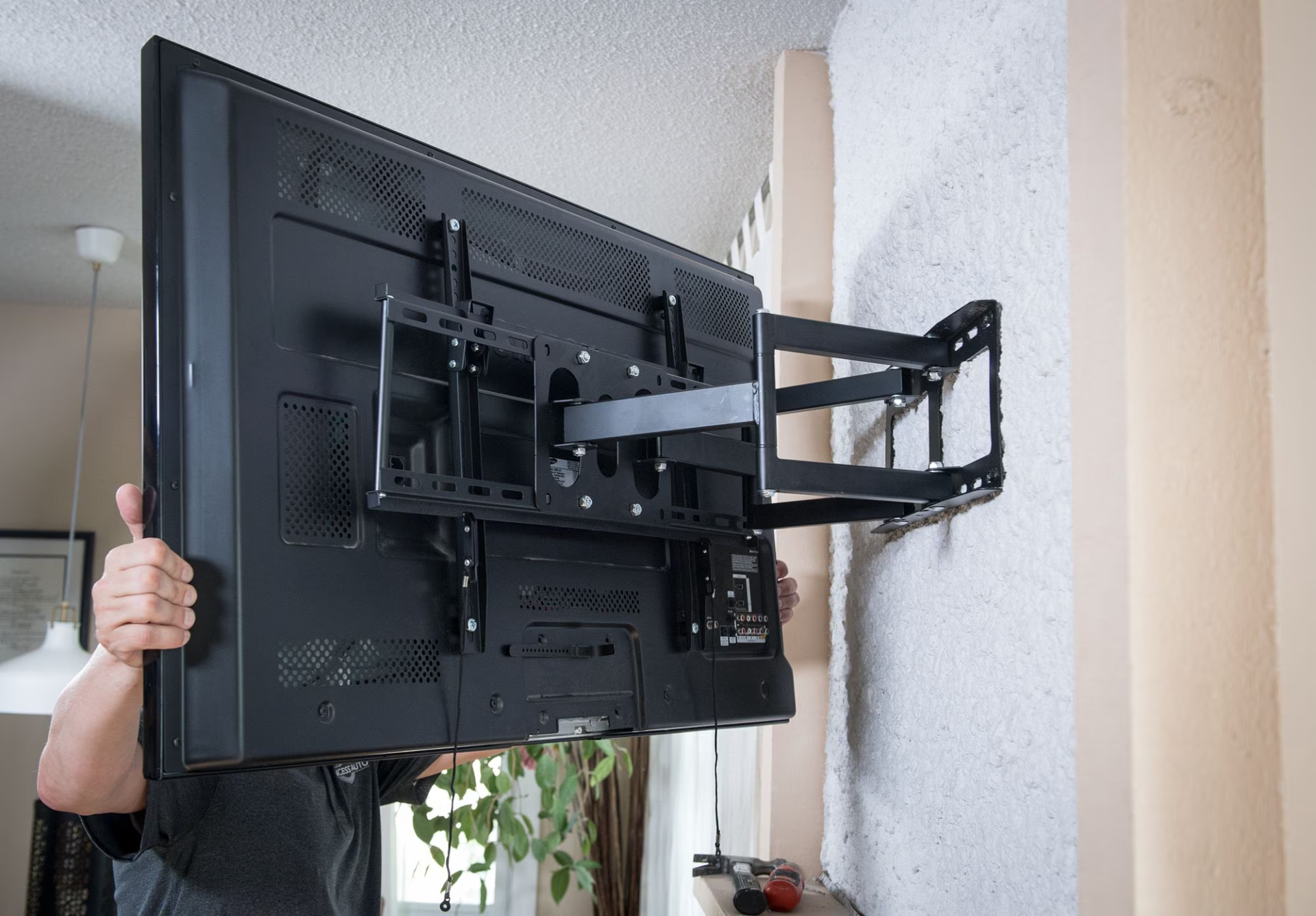 My Ottawa Handyman Professional technician verifying level during TV wall mount installation in Ottawa living room.